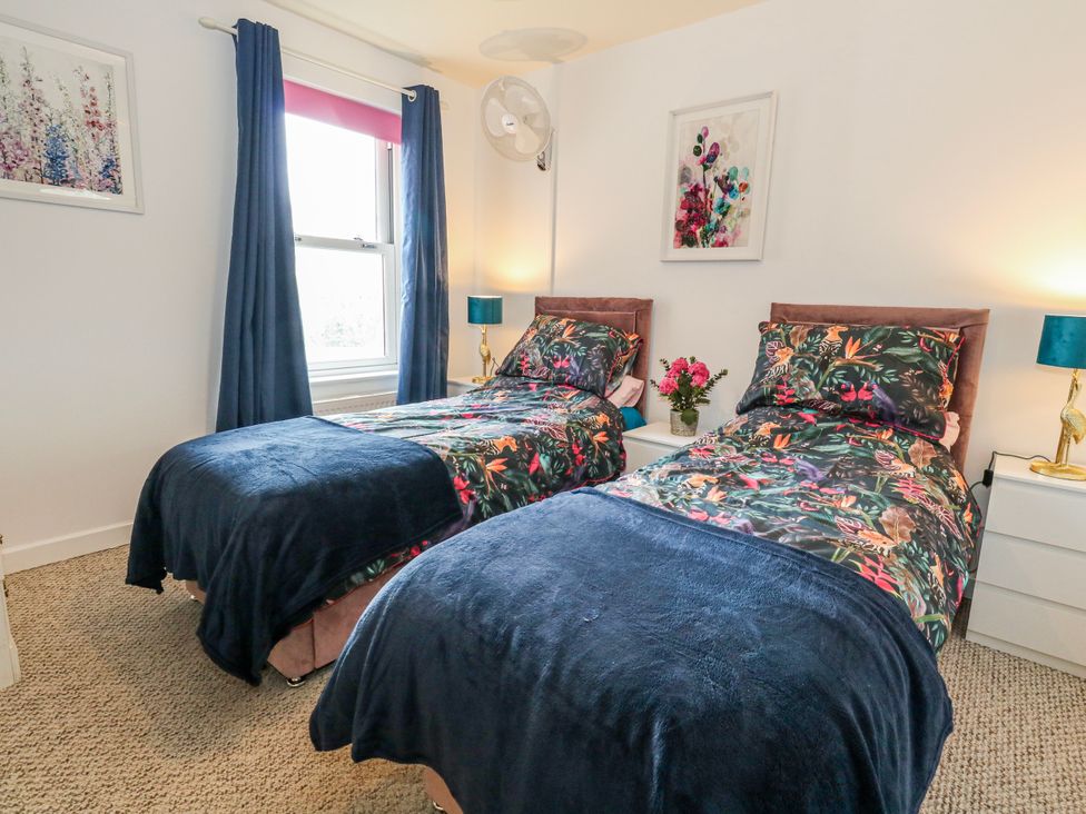 A bedroom with two single beds and a flower vase at Rodwell Holt in Weymouth