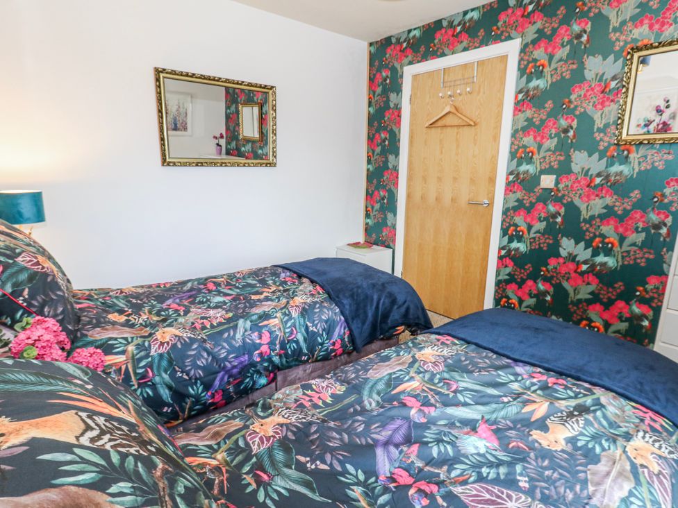 A bedroom with two beds and a mirror at Rodwell Holt in Weymouth