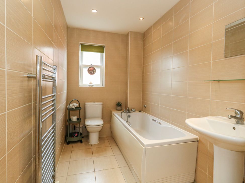 A bathroom with a bathtub, toilet, and washbasin at Rodwell Holt in Weymouth