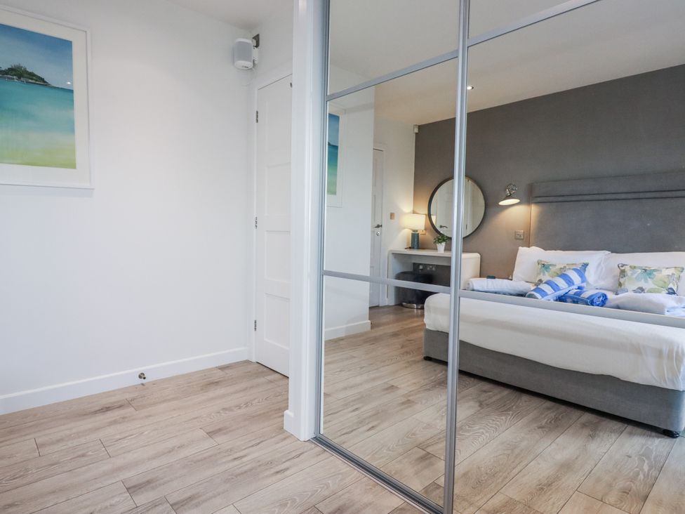 A bedroom with a bed and a mirror at Adelaide in Redruth