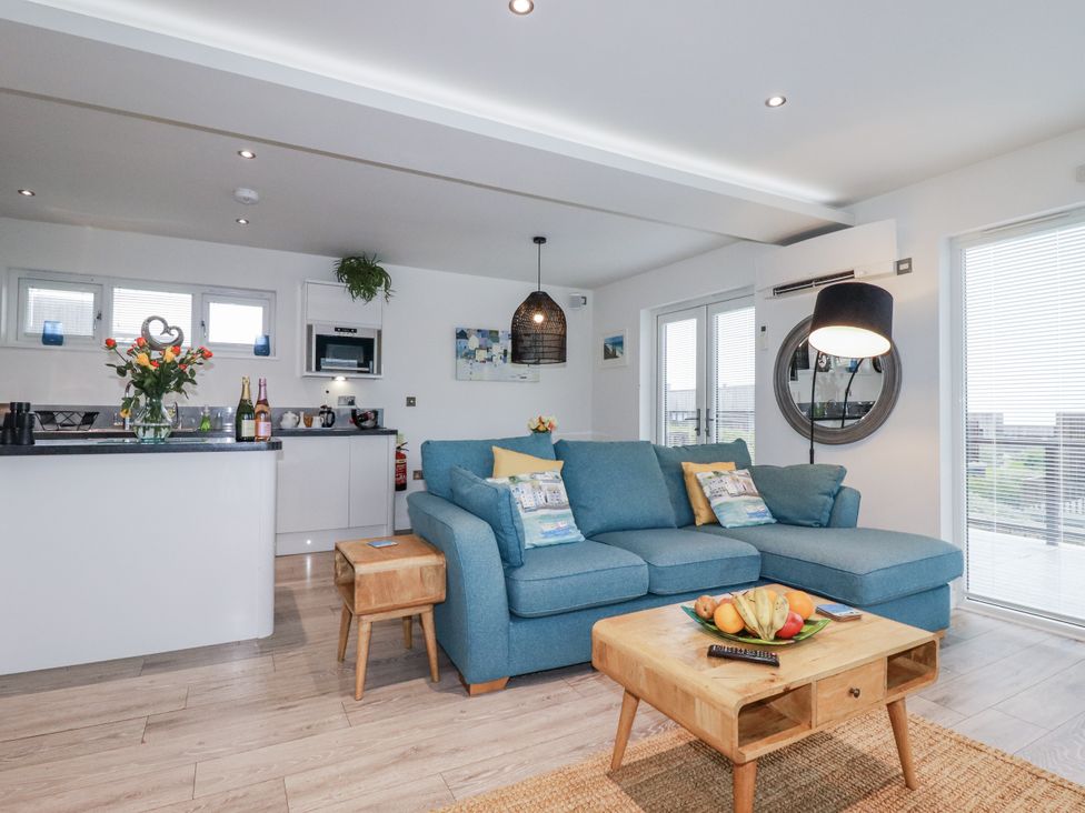 A living room with a blue sofa and a coffee table at Adelaide in Portreath