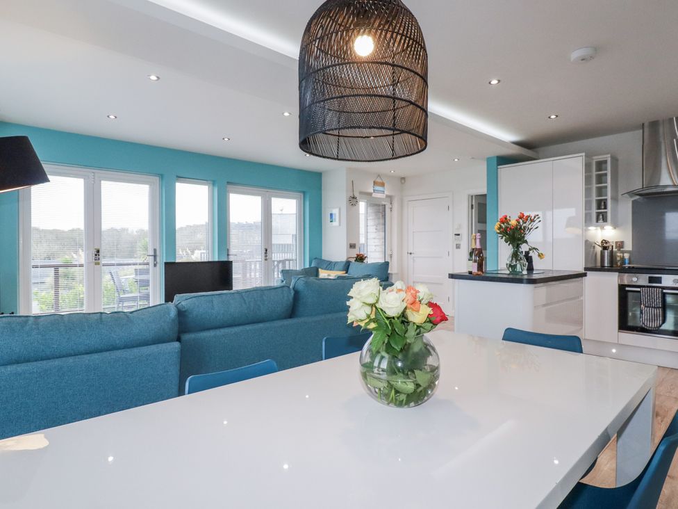 A living room with a sofa and flowers on a table at Adelaide in Portreath