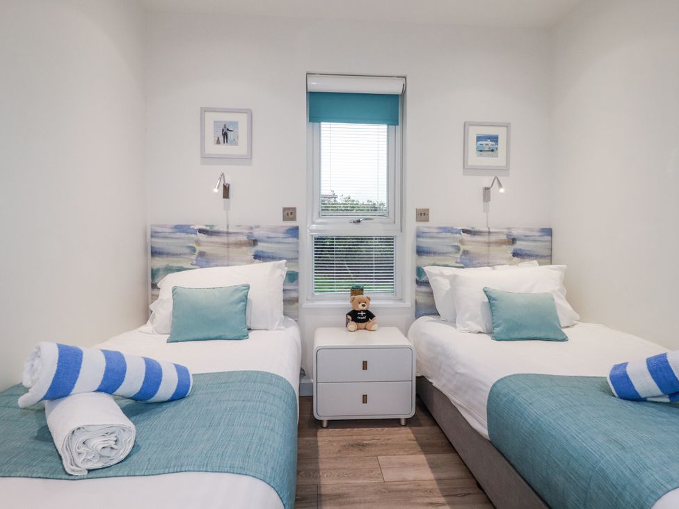 A bedroom with twin beds and a nightstand at Adelaide in Portreath