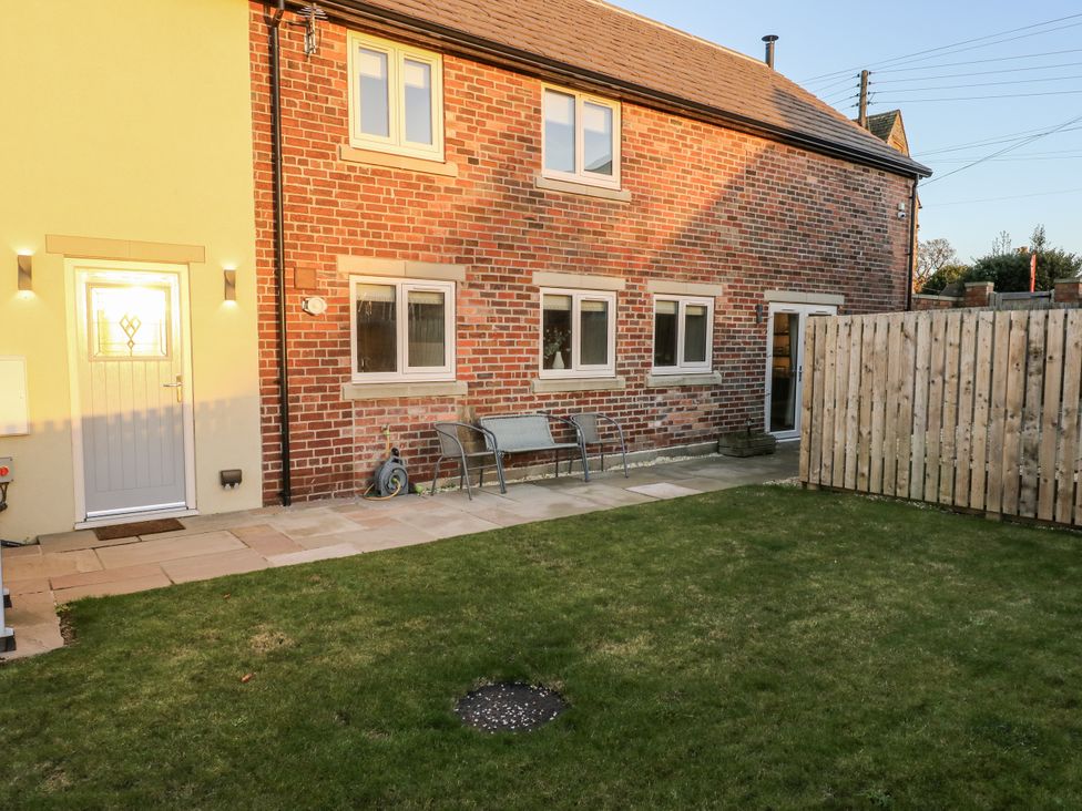 A garden with brick wall and door at The Robins Nest 