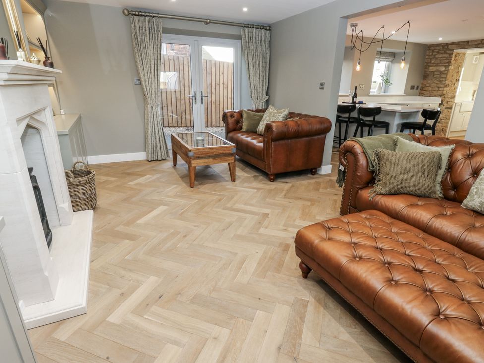 A living room with a brown sofa and coffee table at The Robins Nest 