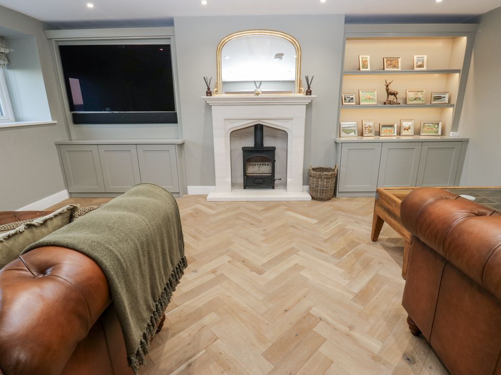 A living room with a fireplace and television at The Robins Nest 