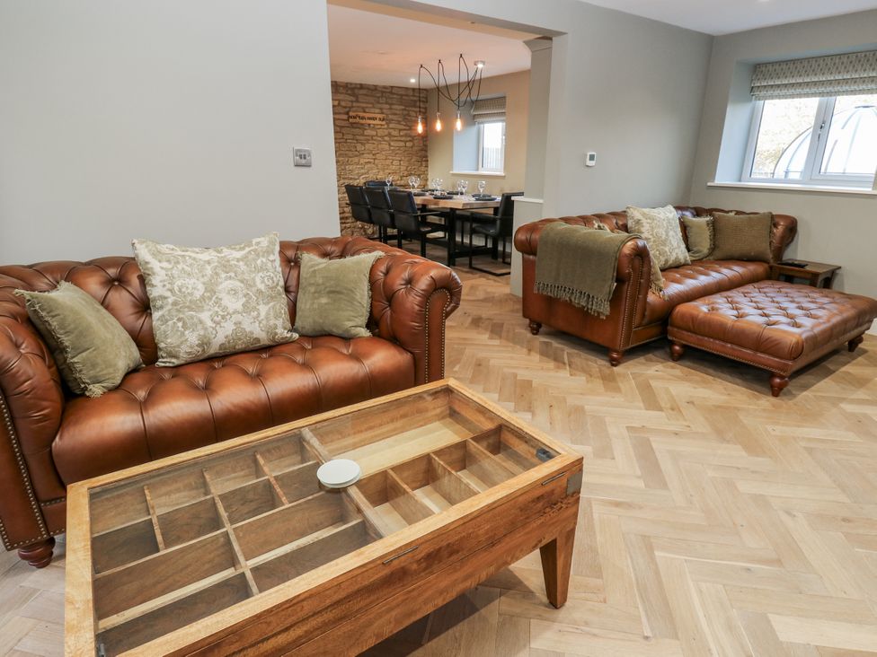 A living room with leather sofas and a wooden coffee table at The Robins Nest