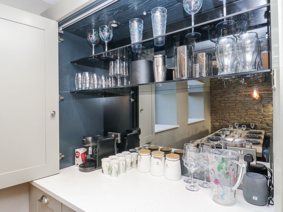 A kitchen with a coffee machine and glassware at The Robins Nest in 