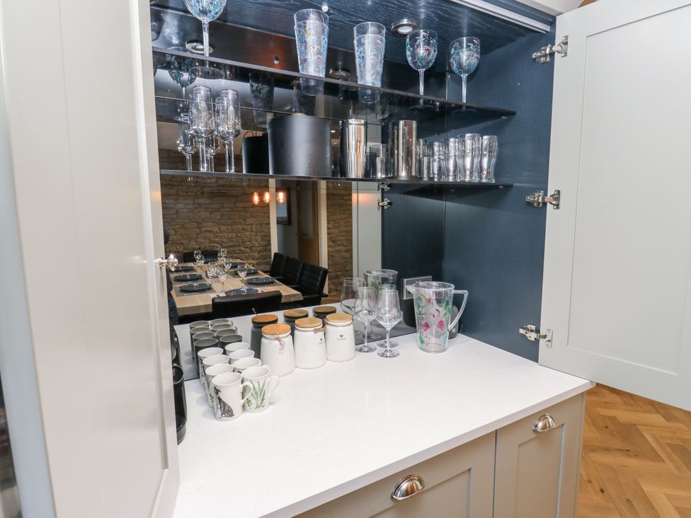 A kitchen cabinet with glassware and mugs at The Robins Nest