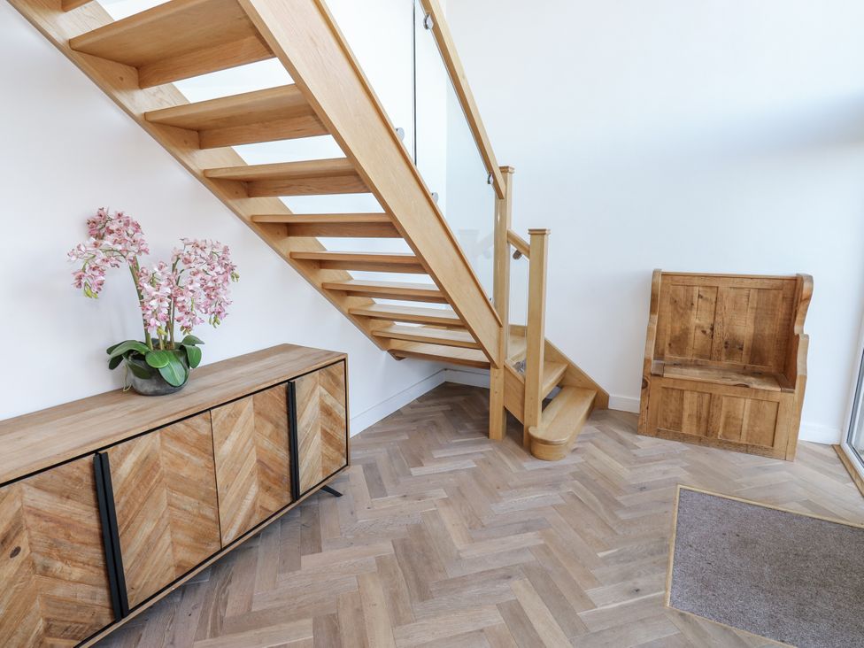 An entryway with a wooden staircase and a plant at The Robins Nest in 