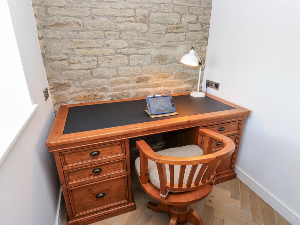 An office with a wooden desk and chair at The Robins Nest in 