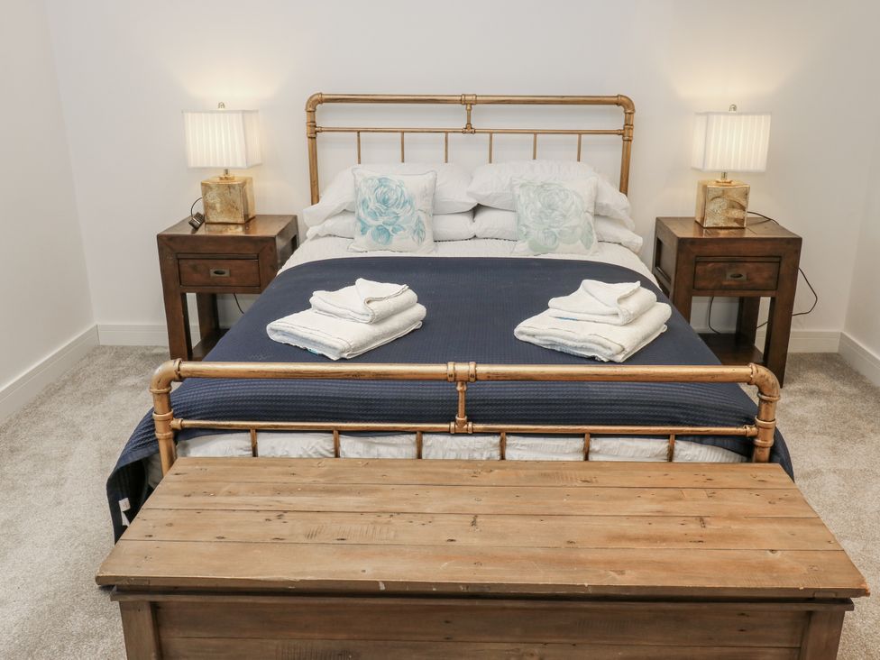 A bedroom with a bed and bedside tables at The Robins Nest