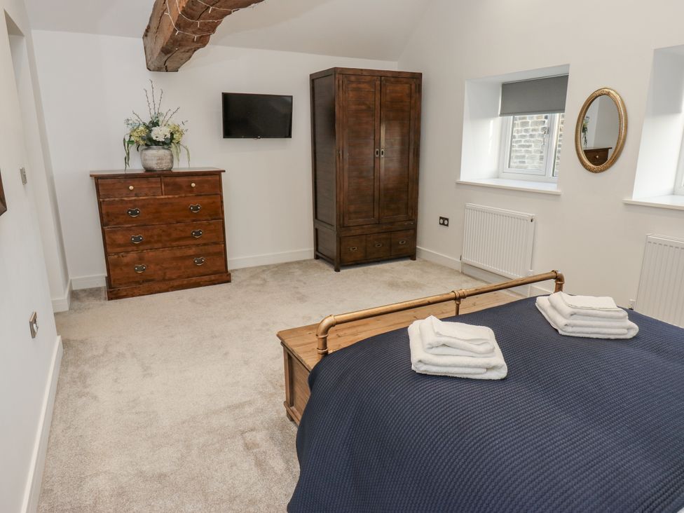 A bedroom with a bed, wardrobe, and dresser at The Robins Nest 