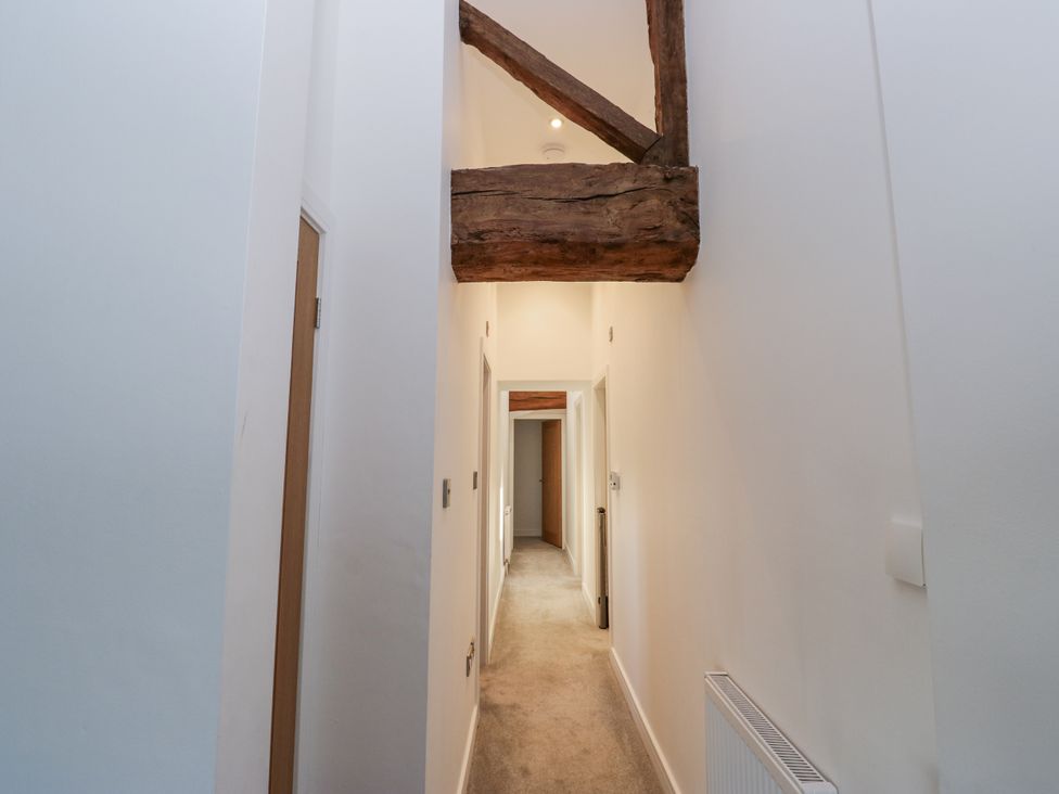 A hallway with doors and a wooden beam at The Robins Nest