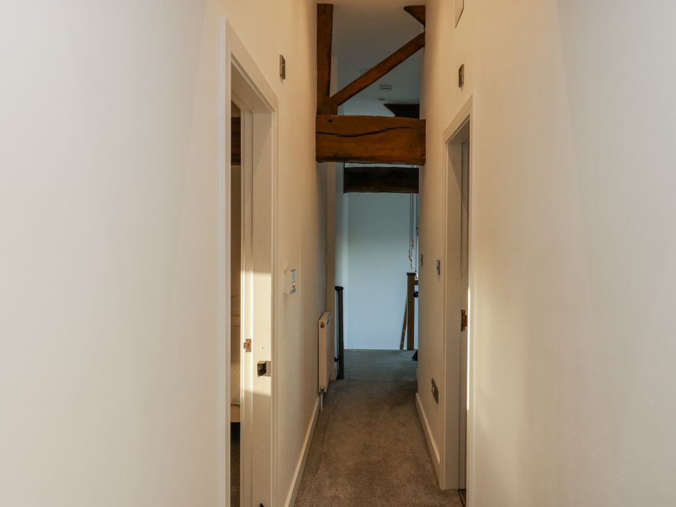 A hallway with doors and a wooden beam at The Robins Nest in 