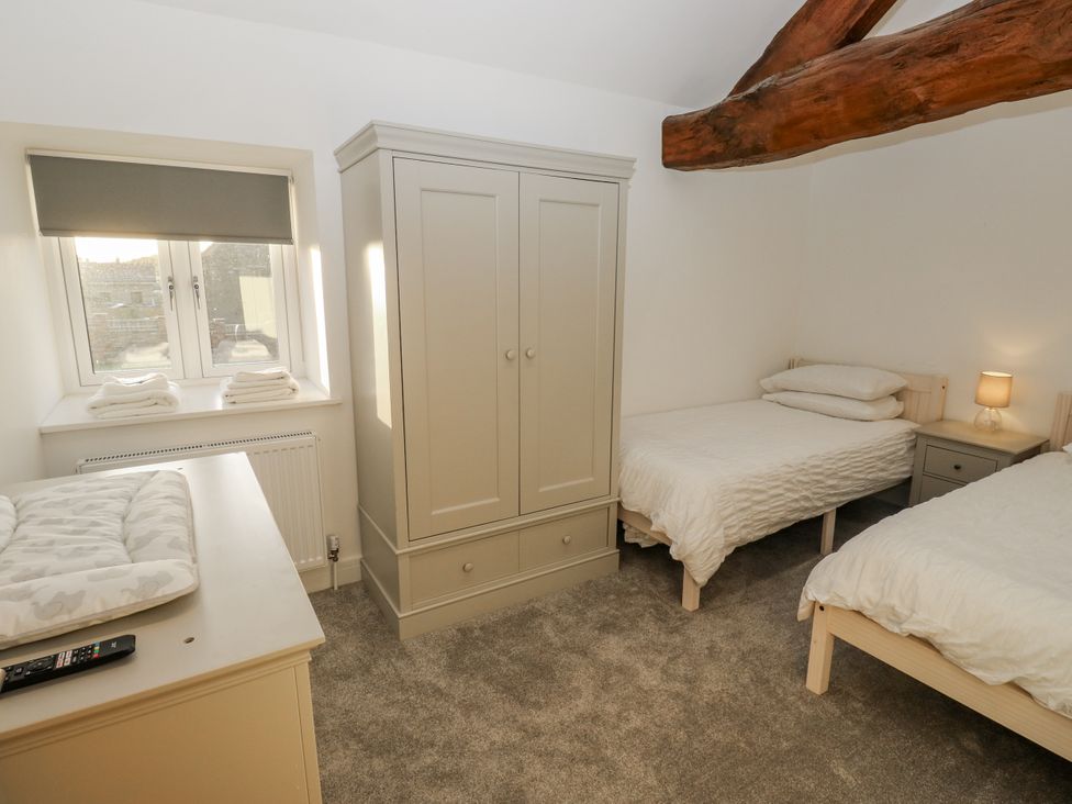 A bedroom with two beds and a wardrobe at The Robins Nest 