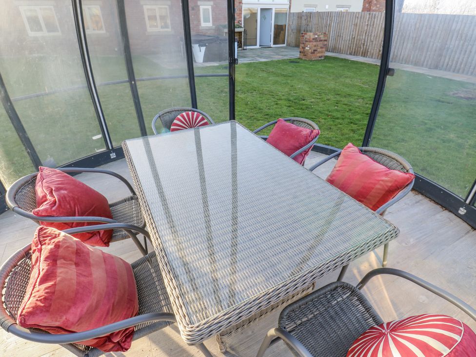 A table with chairs in a conservatory at The Robins Nest