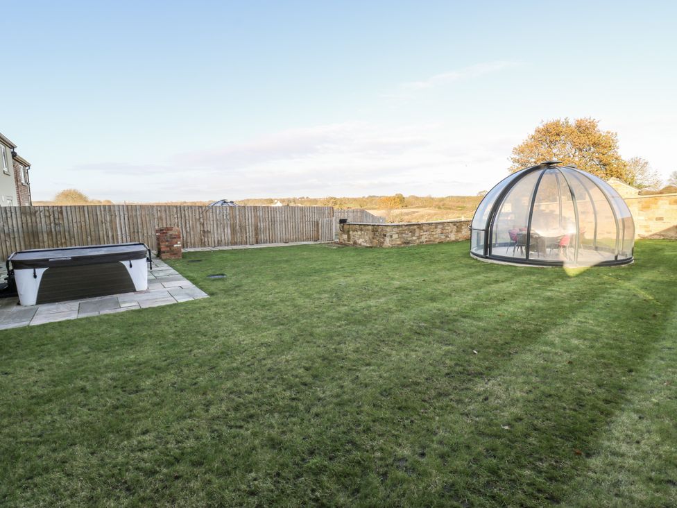 A garden with a hot tub and a glass dome structure at The Robins Nest in 