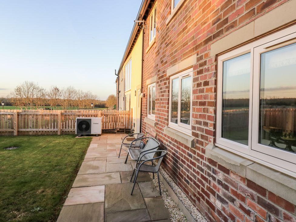 A garden with a patio and chairs at The Robins Nest in 