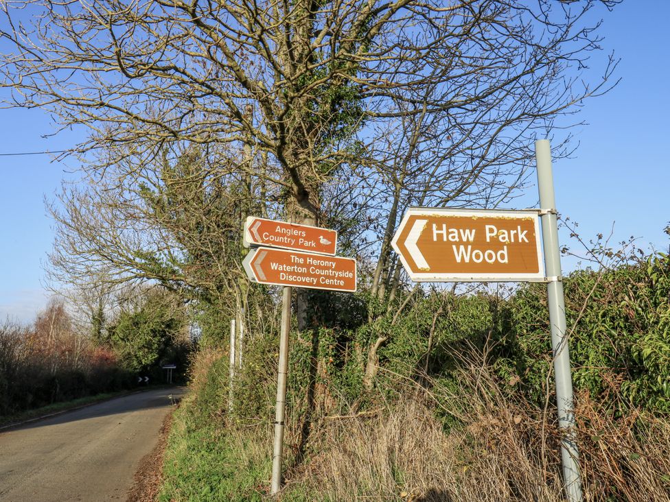 Direction signs along a road indicating Anglers Country Park and Haw Park Wood