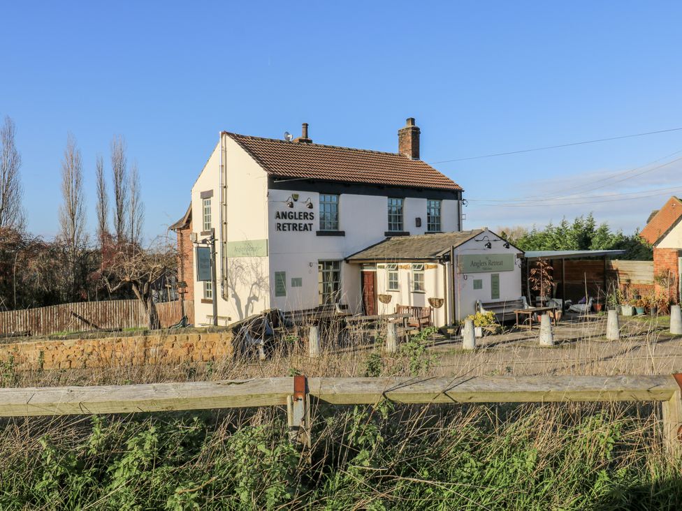 An exterior view of the Anglers Retreat with parking area