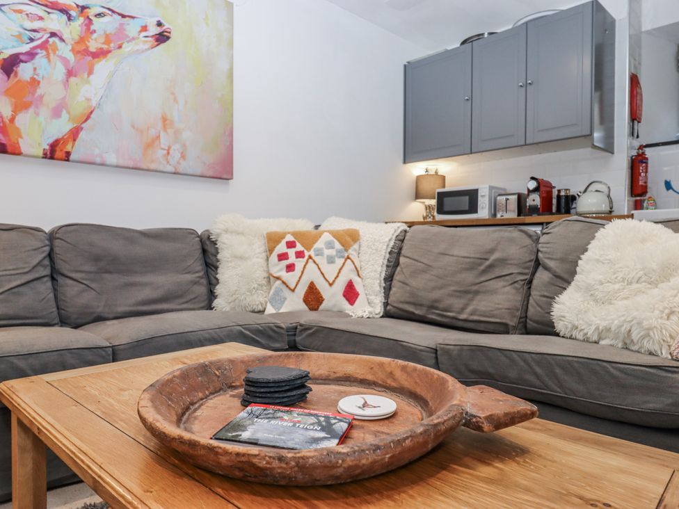 A living room with a grey sofa and a coffee table at Clifford Lodge Barn
