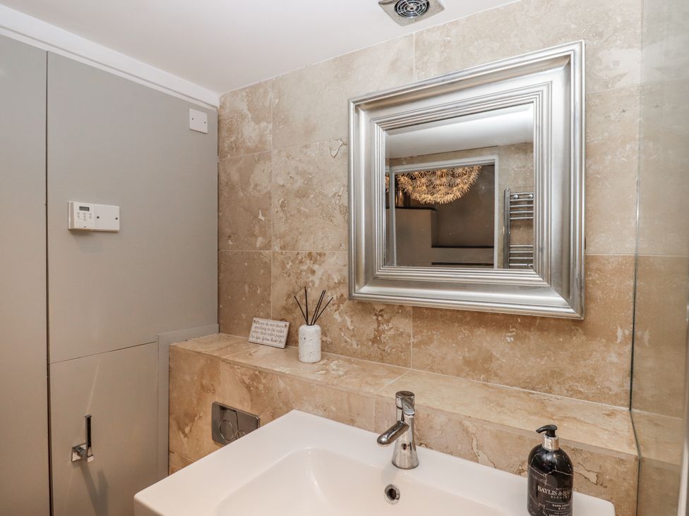 A bathroom with a sink and mirror at Clifford Lodge Barn