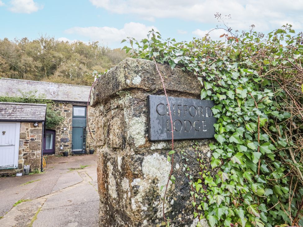 A stone wall with a sign at Clifford Lodge Barn