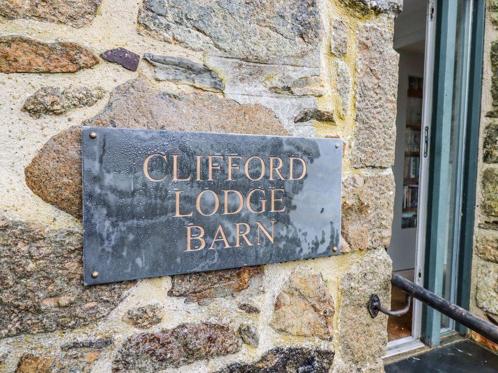 A sign on a stone wall at Clifford Lodge Barn