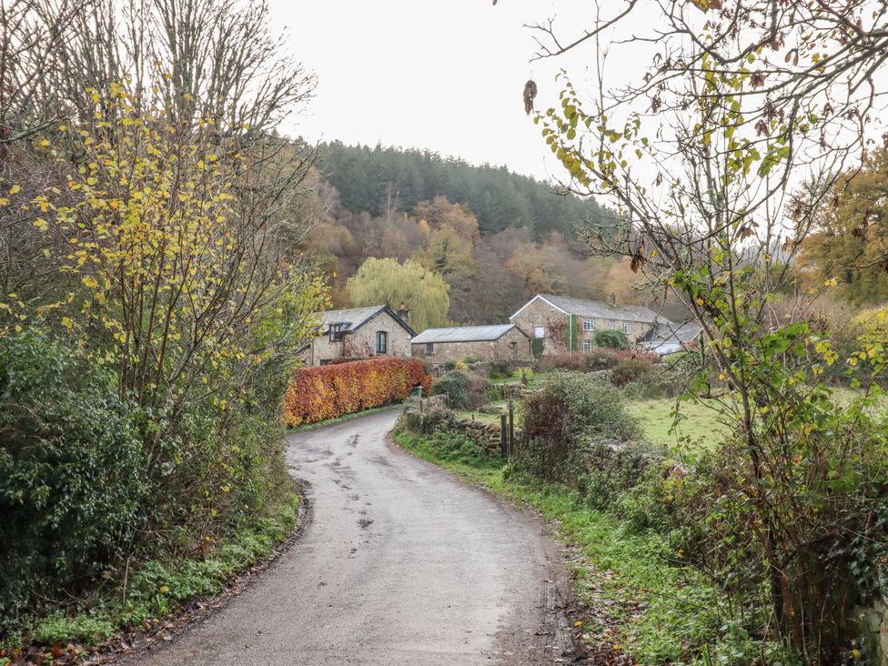 A view of a winding road with buildings and trees at Clifford Lodge Barn