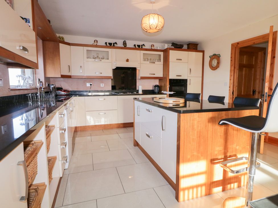 A kitchen with cabinets and an island at Storey and Half House in Annagry