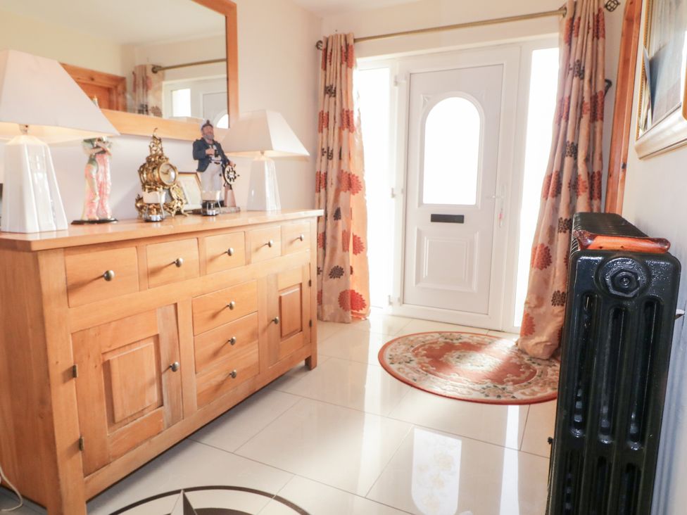 A hallway with a console table and decorative items at Storey and Half House Annagry