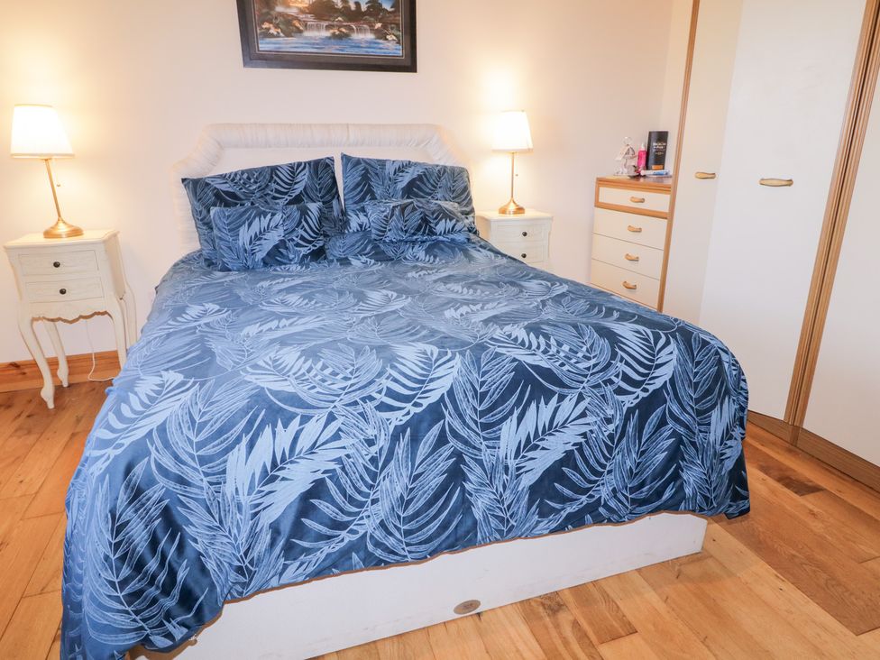 A bedroom with a bed and nightstand at Storey and Half House Annagry