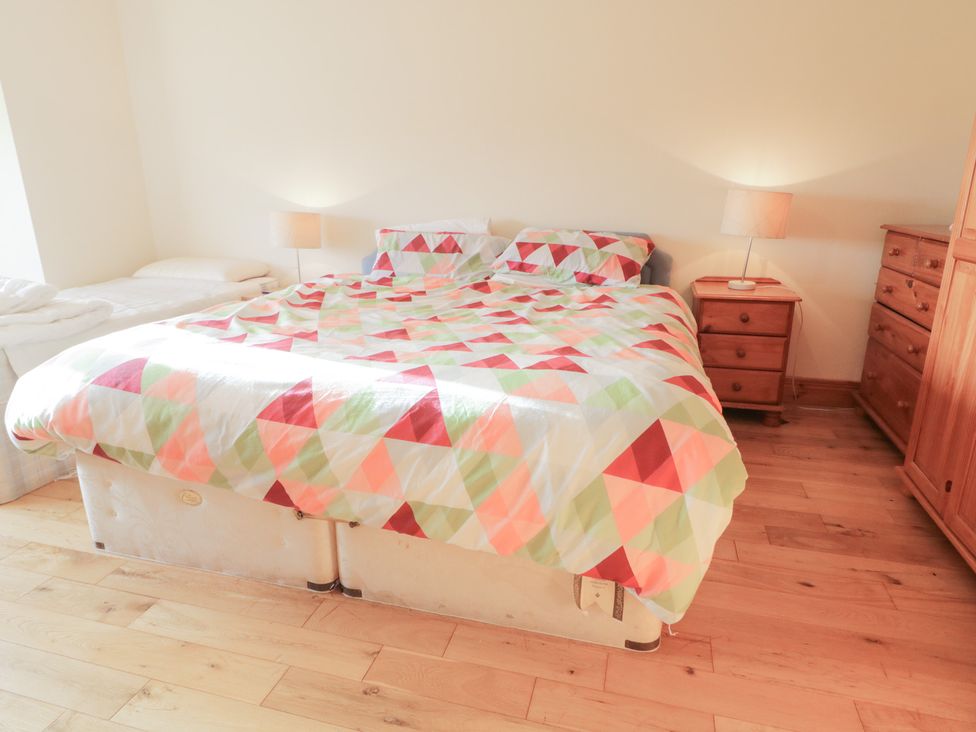 A bedroom with a bed and nightstand at Storey and Half House in Annagry
