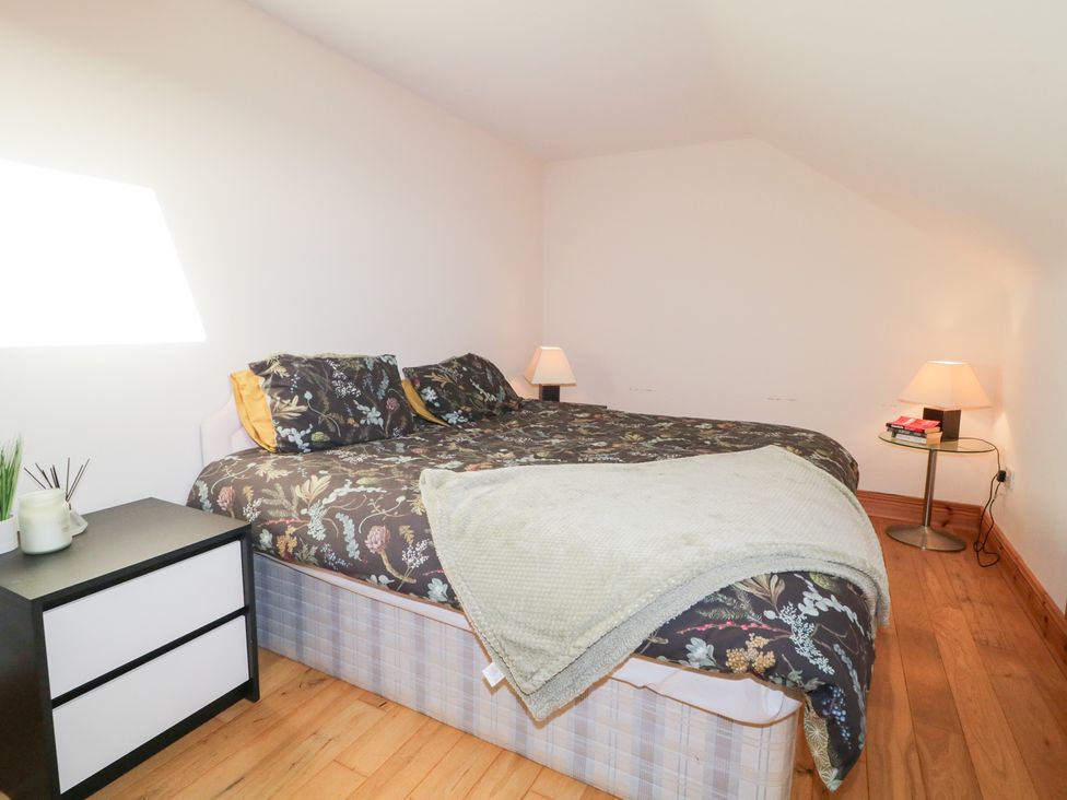 A bedroom with a bed and bedside lamps at Storey and Half House in Annagry