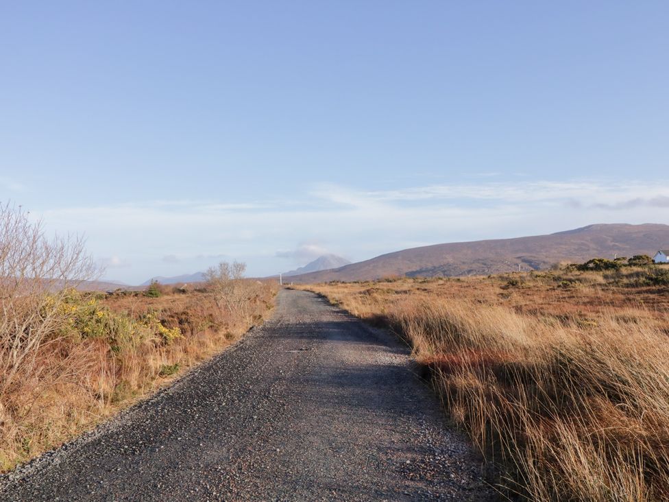 A gravel road leading to mountains at Storey and Half House in Annagry