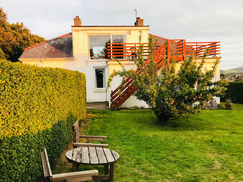 A house with a deck and stairs in the garden at Storey and Half House Near Annagry, County Donegal