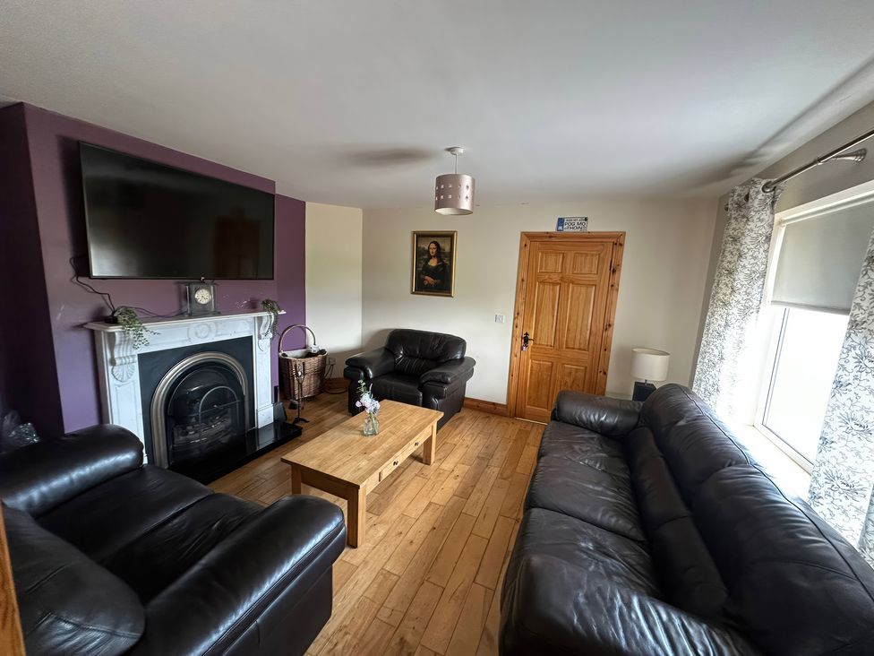 A living room with a television and fireplace at Storey and Half House Near Annagry, County Donegal