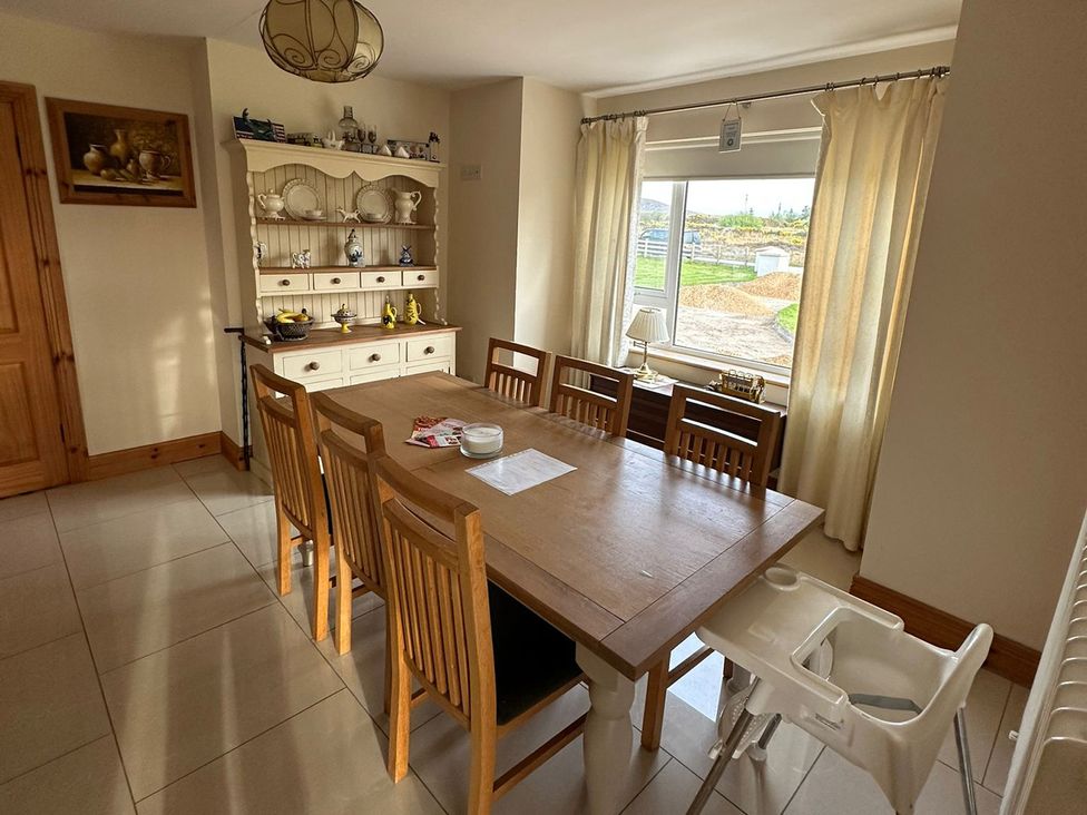 A dining room with a table and chairs at Storey and Half House Near Annagry, County Donegal