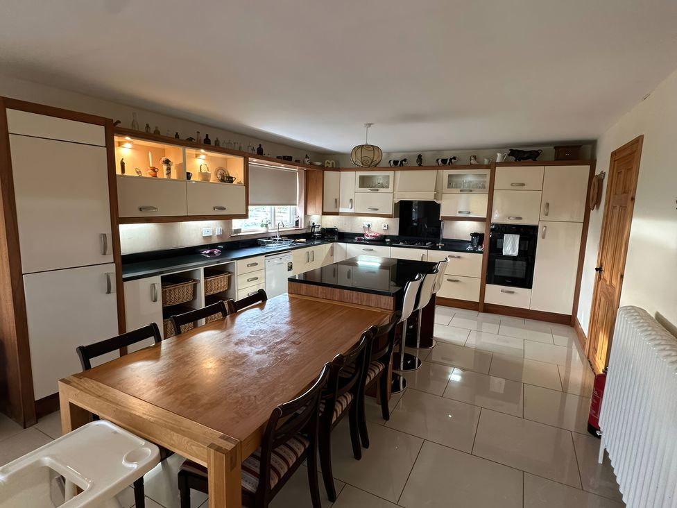 A kitchen with a dining table and chairs at Storey and Half House Near Annagry, County Donegal
