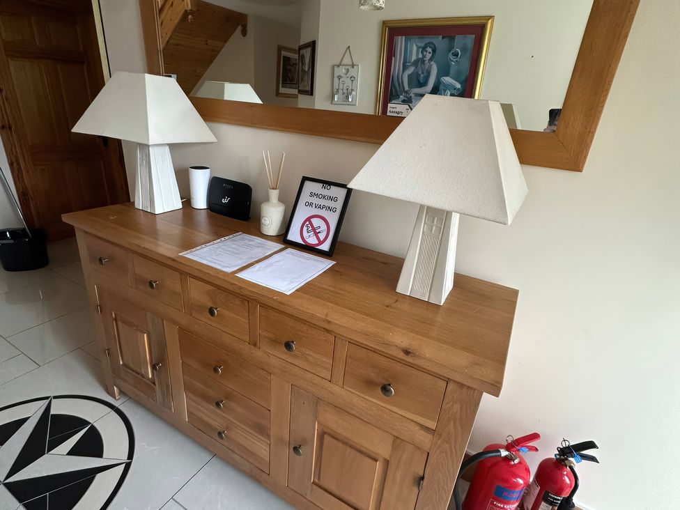 A dresser with lamps and a sign in the hallway at Storey and Half House Near Annagry, County Donegal