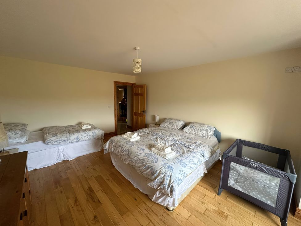 A bedroom with two beds and a crib at Storey and Half House Near Annagry, County Donegal