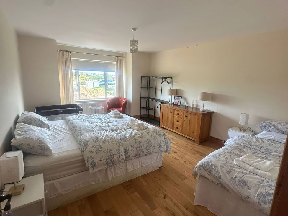 A bedroom with two beds and a dresser at Storey and Half House near Annagry, County Donegal