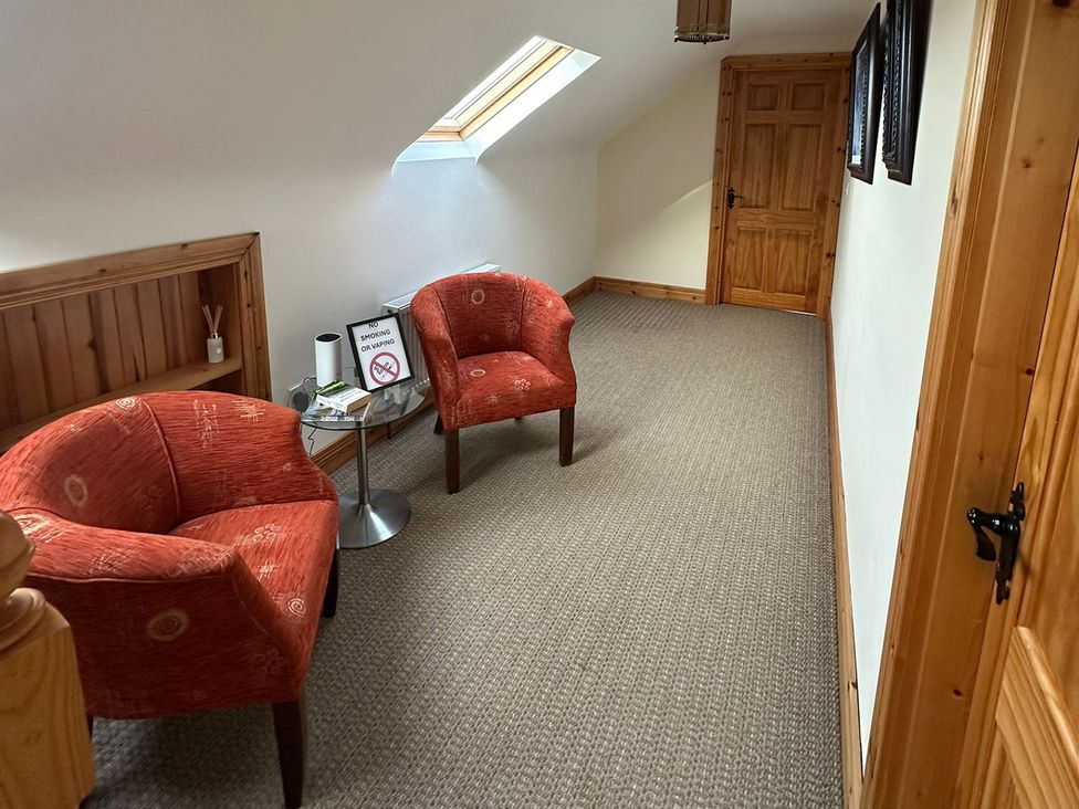 A hallway with chairs and a table at Storey and Half House Near Annagry, County Donegal