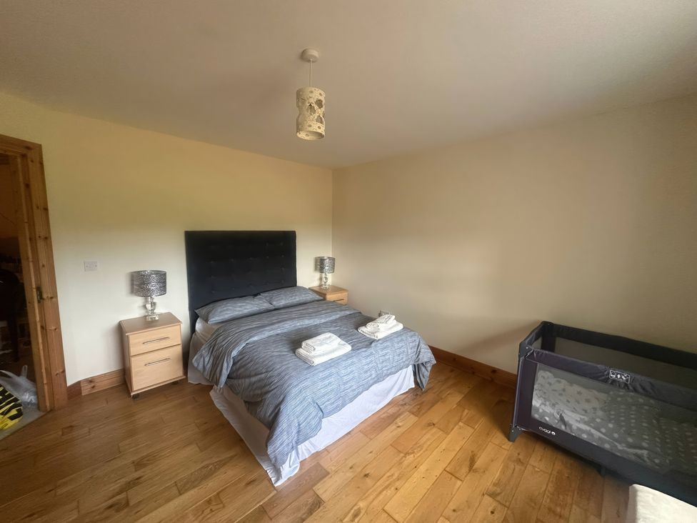 A bedroom with a bed and crib at Storey and Half House Near Annagry, County Donegal