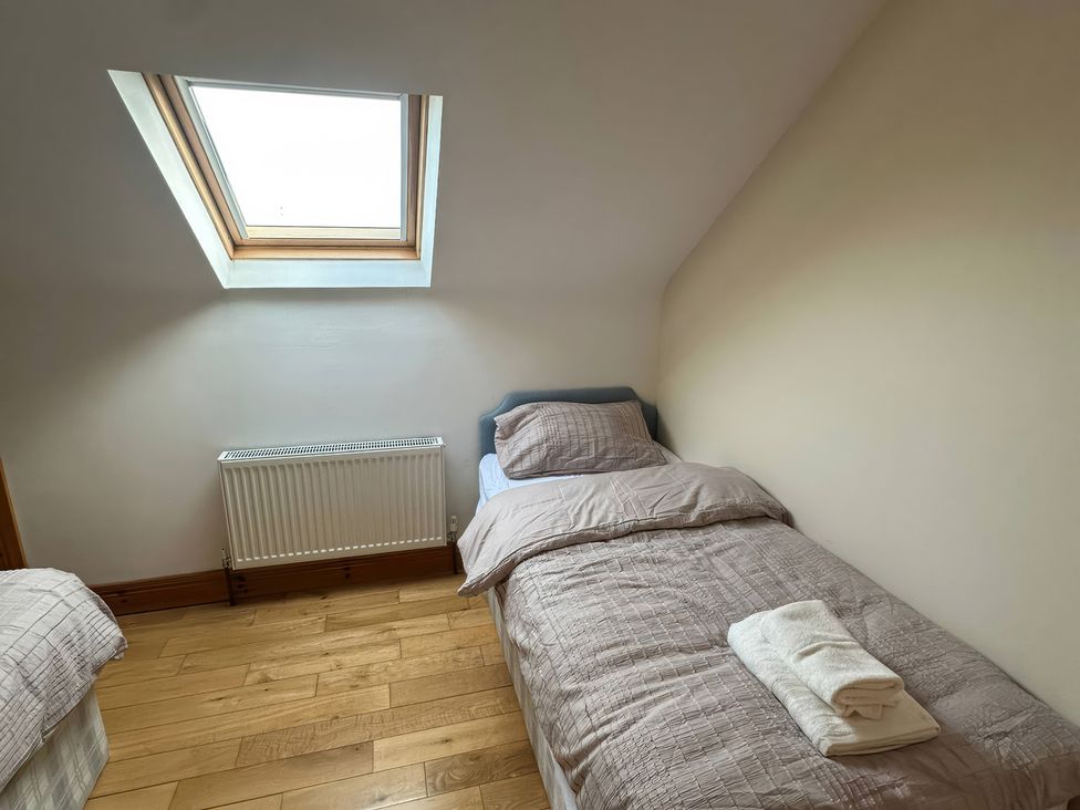 A bedroom with beds and a window at Storey and Half House near Annagry, County Donegal