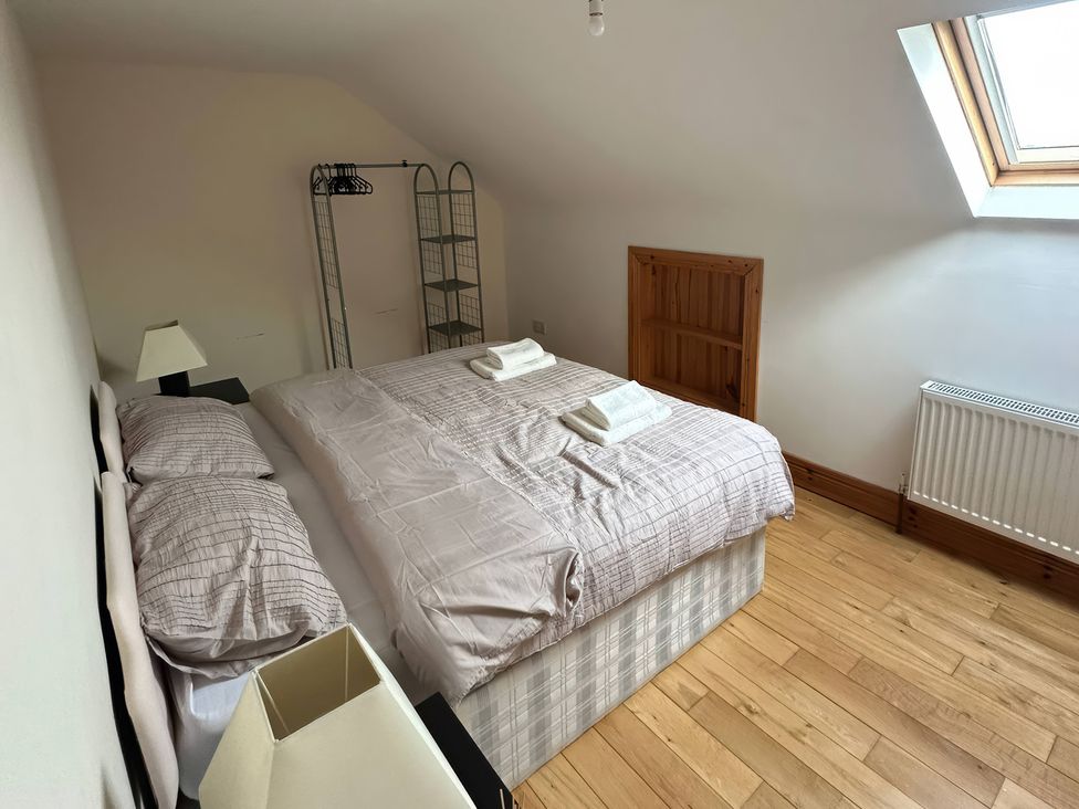 A bedroom with a large bed and shelves at Storey and Half House Near Annagry, County Donegal
