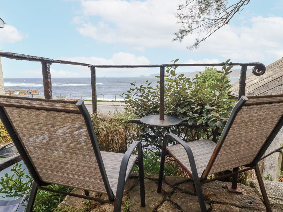 An outdoor space with chairs and table overlooking the ocean at Cove Retreat in Penzance