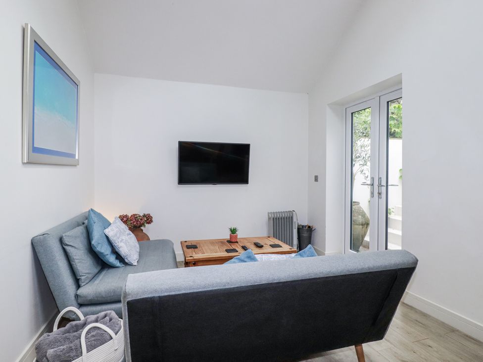 A living room with a sofa and television at Cove Retreat in Penzance
