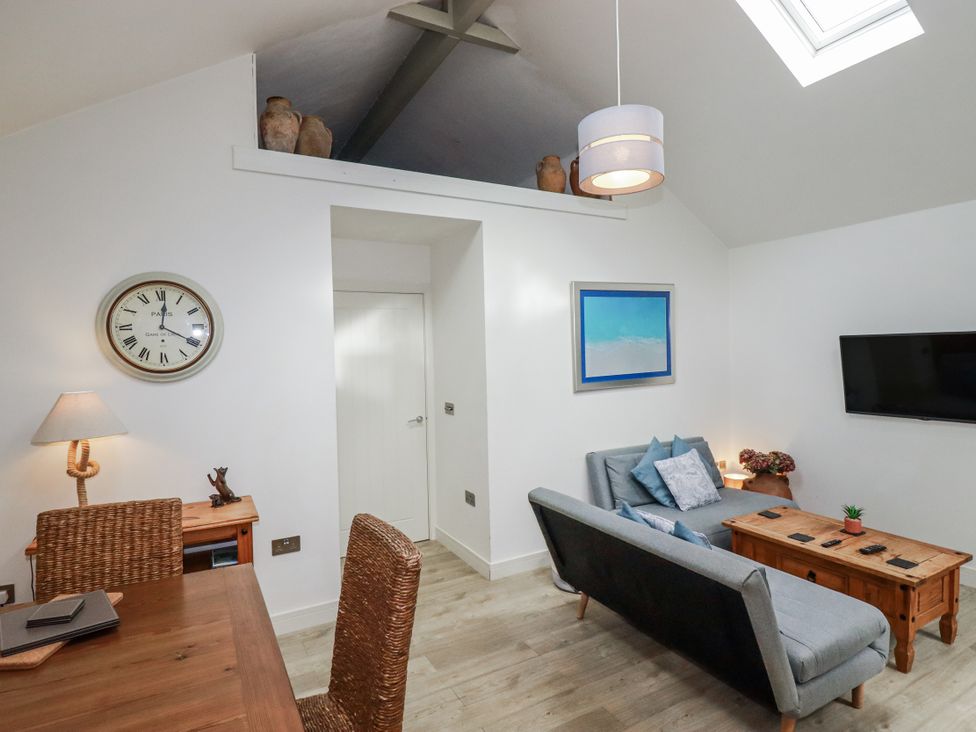A living room with a sofa and table at Cove Retreat in Penzance